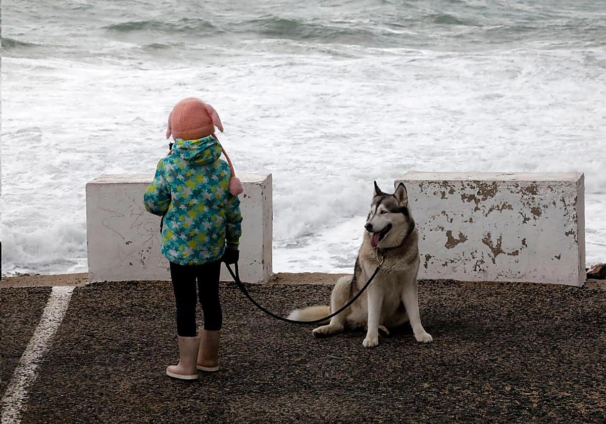 Una niña mira el temporal en Dénia.
