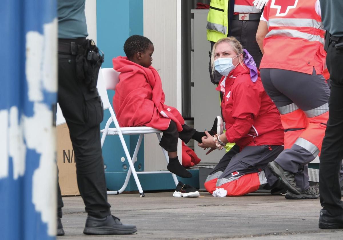 Red Cross personnel attend to a minor arriving by boat in the Canary Islands.