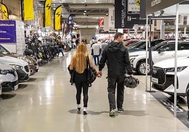 Una pareja observa los vehículos.