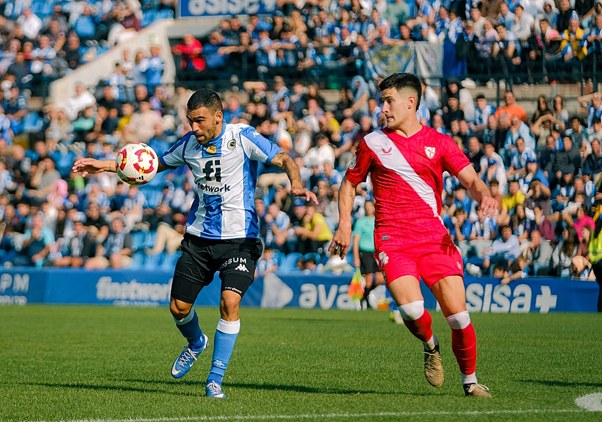 Romera attempts to score against a Sevilla Atlético player.