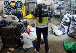Agente de Policía Nacional, en el almacén de ropa usada objeto de la operación.