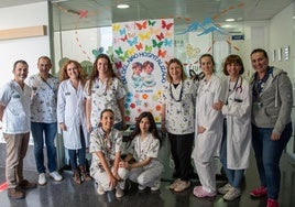 Personal sanitario de Dénia junto al mural elaborado por los propios menores ingresados.