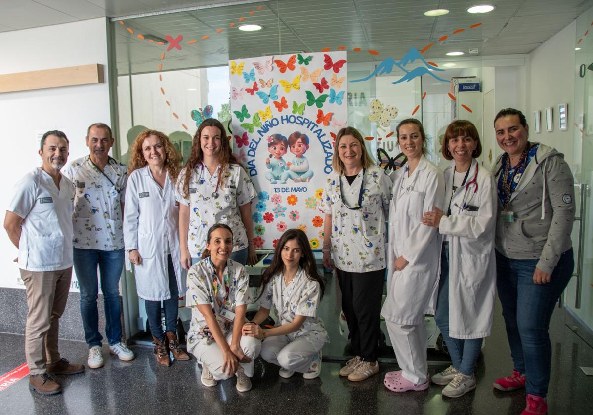 Personal sanitario de Dénia junto al mural elaborado por los propios menores ingresados.