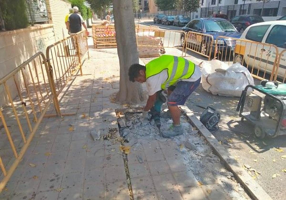 Un operario repara una acera de Alicante, en imagen de archivo.