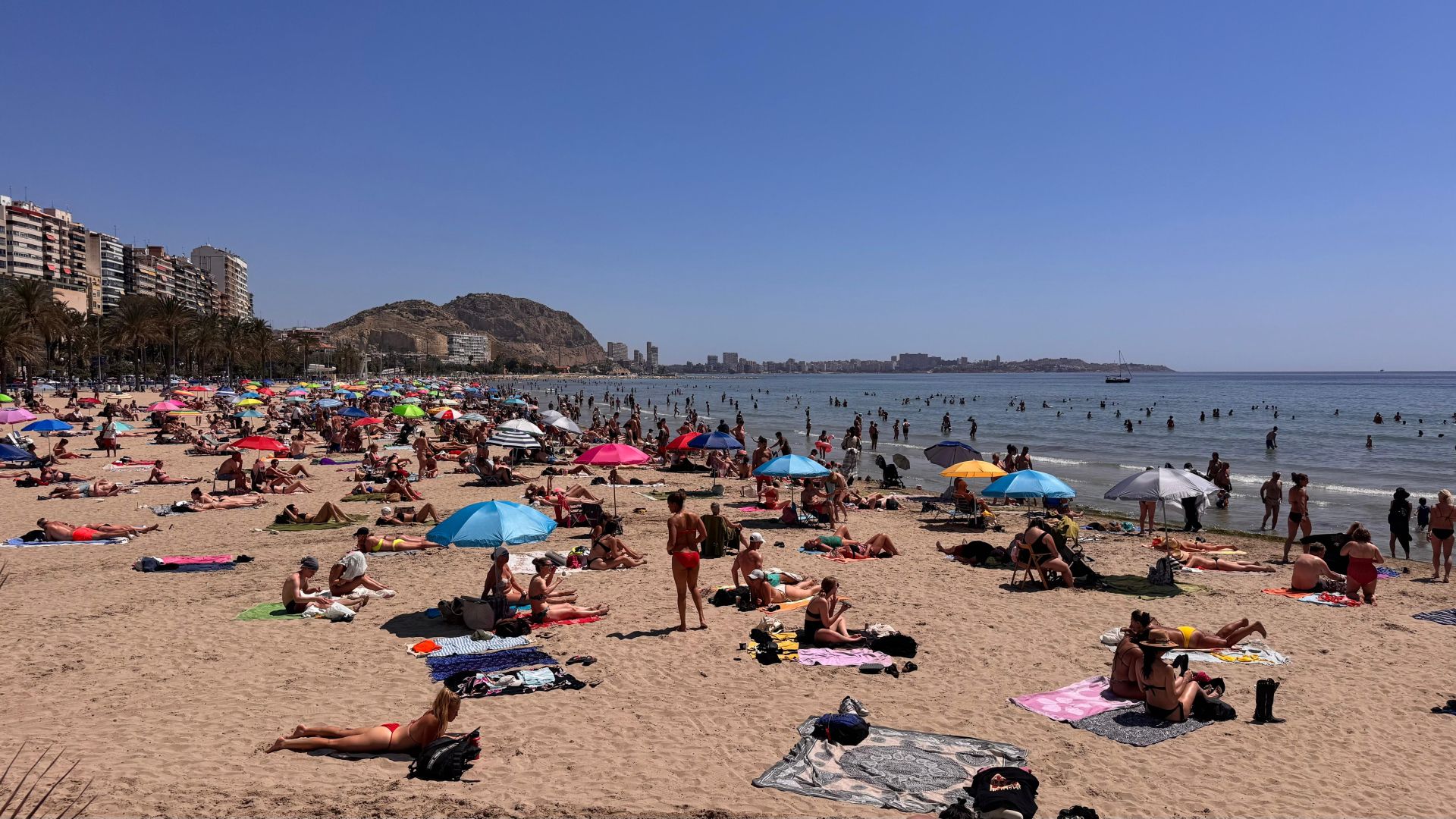 People on Postiguet beach on a hot May day.