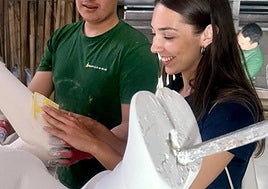 La bellea de Port d'Alacant lija uno de los ninots.