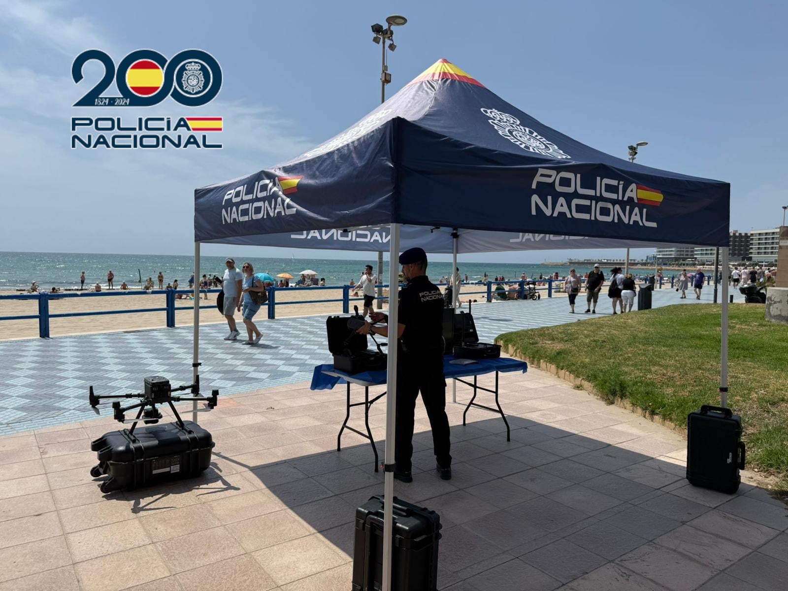Un agente de la Unidad de Medios Aéreos con uno de los drones en la playa del Postiguet.