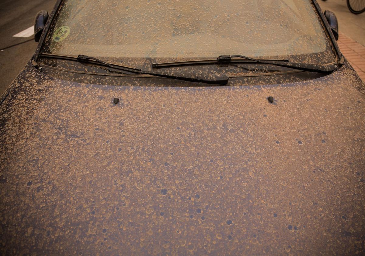 Coche cubierto de barro tras lluvia con calima.