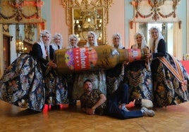 La bellea del foc y sus dames d'honor sostienen un botellín gigante diseñado por Antonyo Marest.