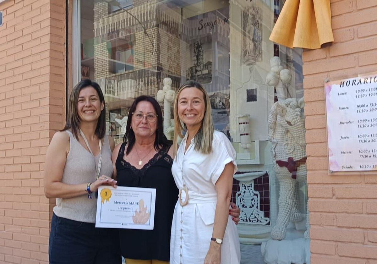 Las propietarias de la mercería recibe el premio de la concejal de Comercio, Lidia López (d).