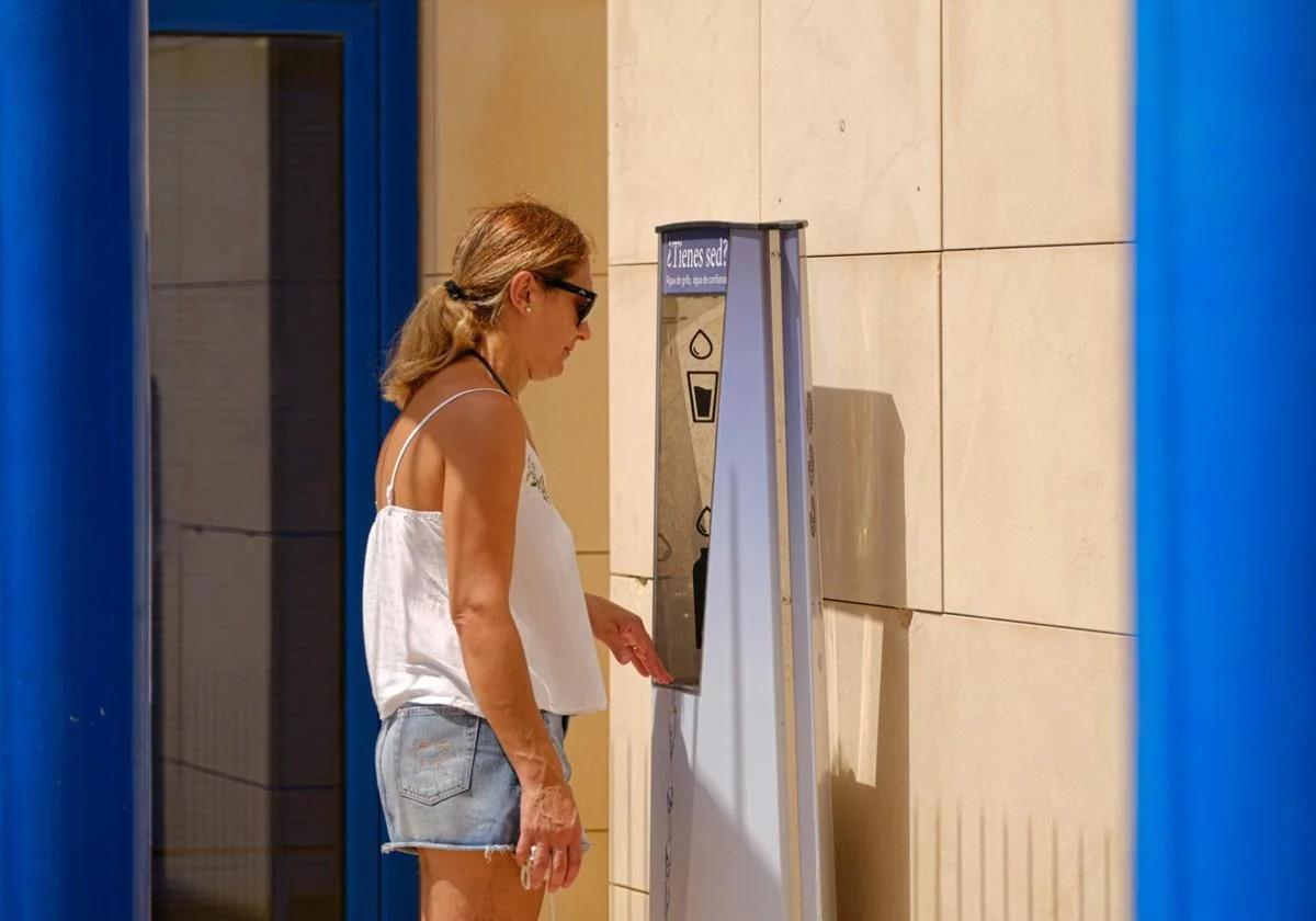 Una ciudadana utiliza una de las fuentes de agua gratis instaladas en Alicante.