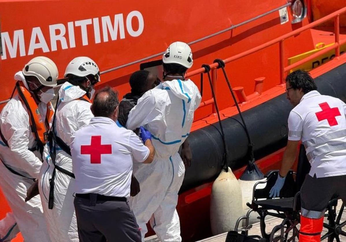 Red Cross members attend to a person upon arrival at the port of Alicante.