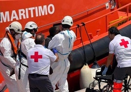 Miembros de Cruz Roja atienden a una persona a su llegada al puerto de Alicante.