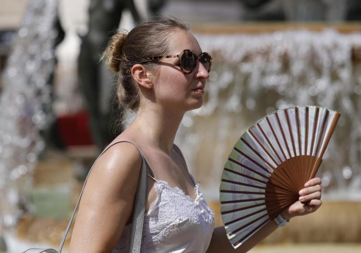 Una viandante se abanica para combatir el calor.