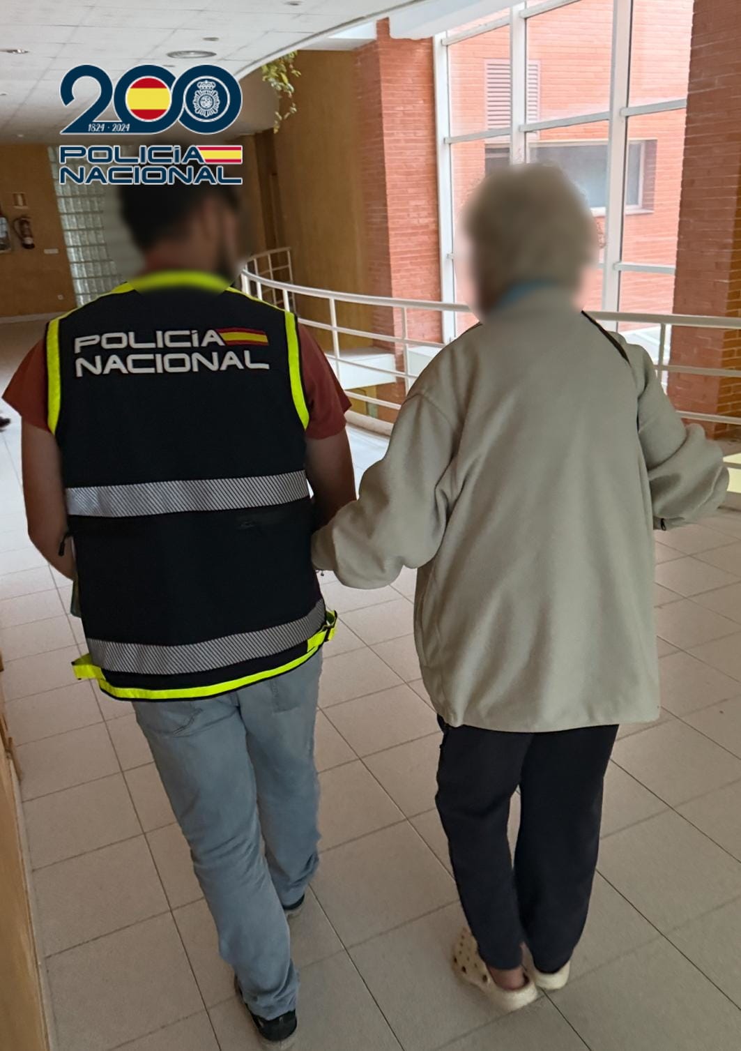 Un agente de la Policía Nacional junto a la víctima.