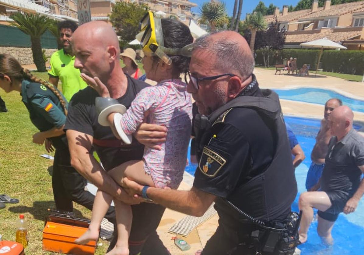 The young girl is carried to safety after being rescued.