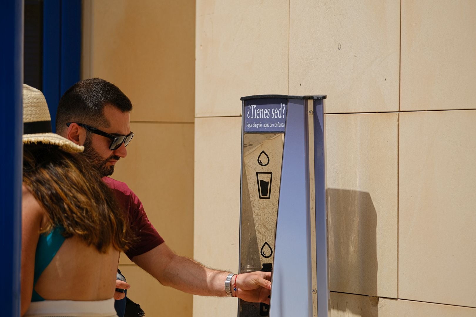A person refills their water bottle at a fountain in Postiguet.