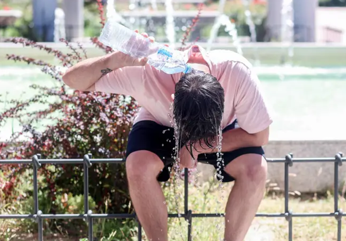 Una persona se refresca con agua en la calle ante el intenso calor.