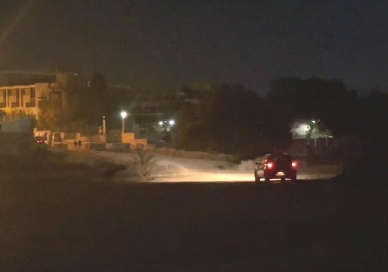 Vehicles drive along Almadraba Beach.