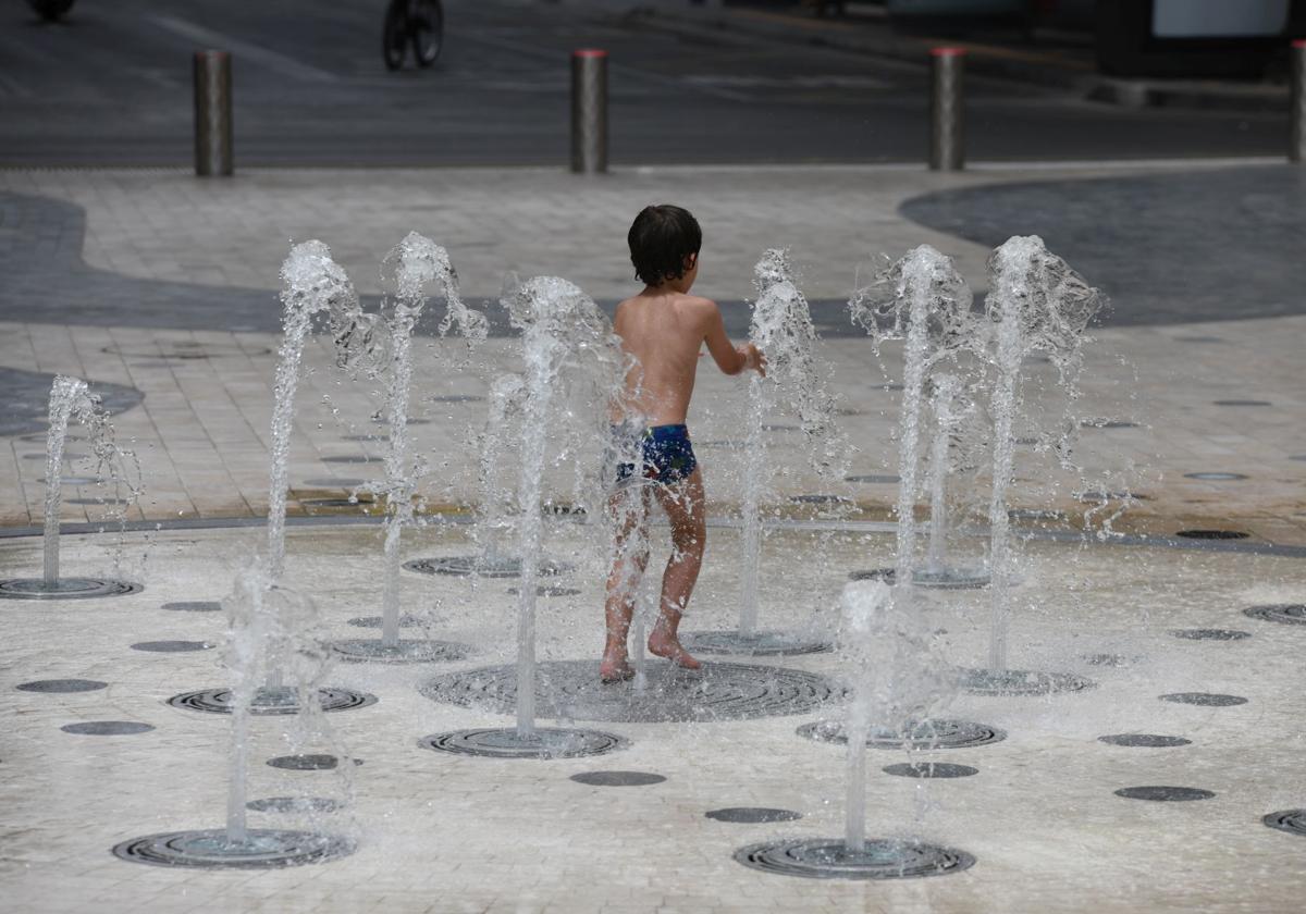 A child cools off playing in a fountain in Alicante.