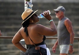 Una mujer bebiendo agua durante la jornada de calor,