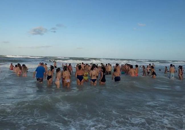 A hundred people bathe at Babilonia Beach.