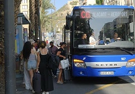 Turistas hacen cola en la parada del Mercado Central para coger el autobús del aeropuerto.