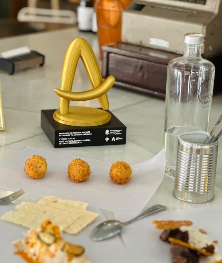 Imagen secundaria 2 - Santabar con el primer premio del certamen, su coca amb tonyina y croquetas.