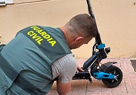 Uno de los agentes que han participado en la operación, junto al patinete recuperado en Dolores.