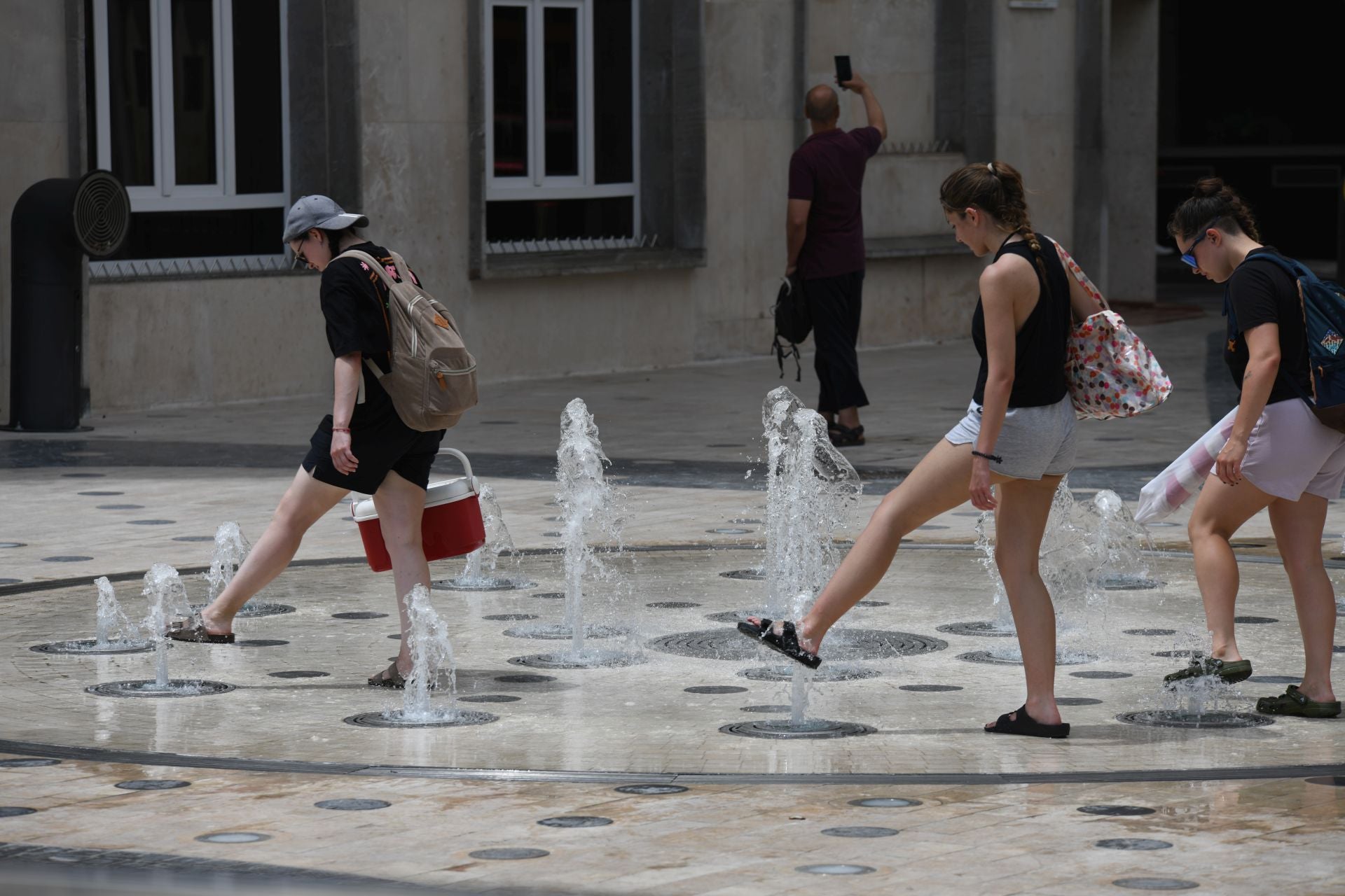 Varias personas se refrescan en Alicante.