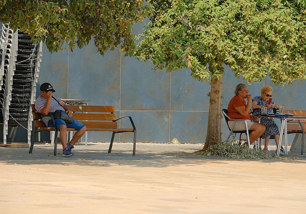 Transeúntes buscan la sombra en Alicante para refugiarse del calor extremo.