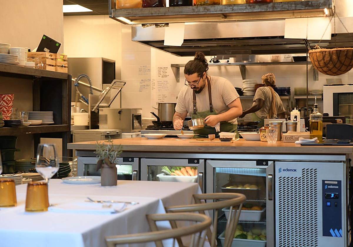 Imagen principal - 1. Cocina abierta del Borg, Raíces y Alas. 2. Sala del Borg. 3. Recetario de la madre de Carl Borg que decora una de las paredes del establecimiento. 