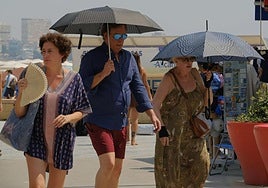 Varias personas combaten el calor en la playa del Postiguet de Alicante.