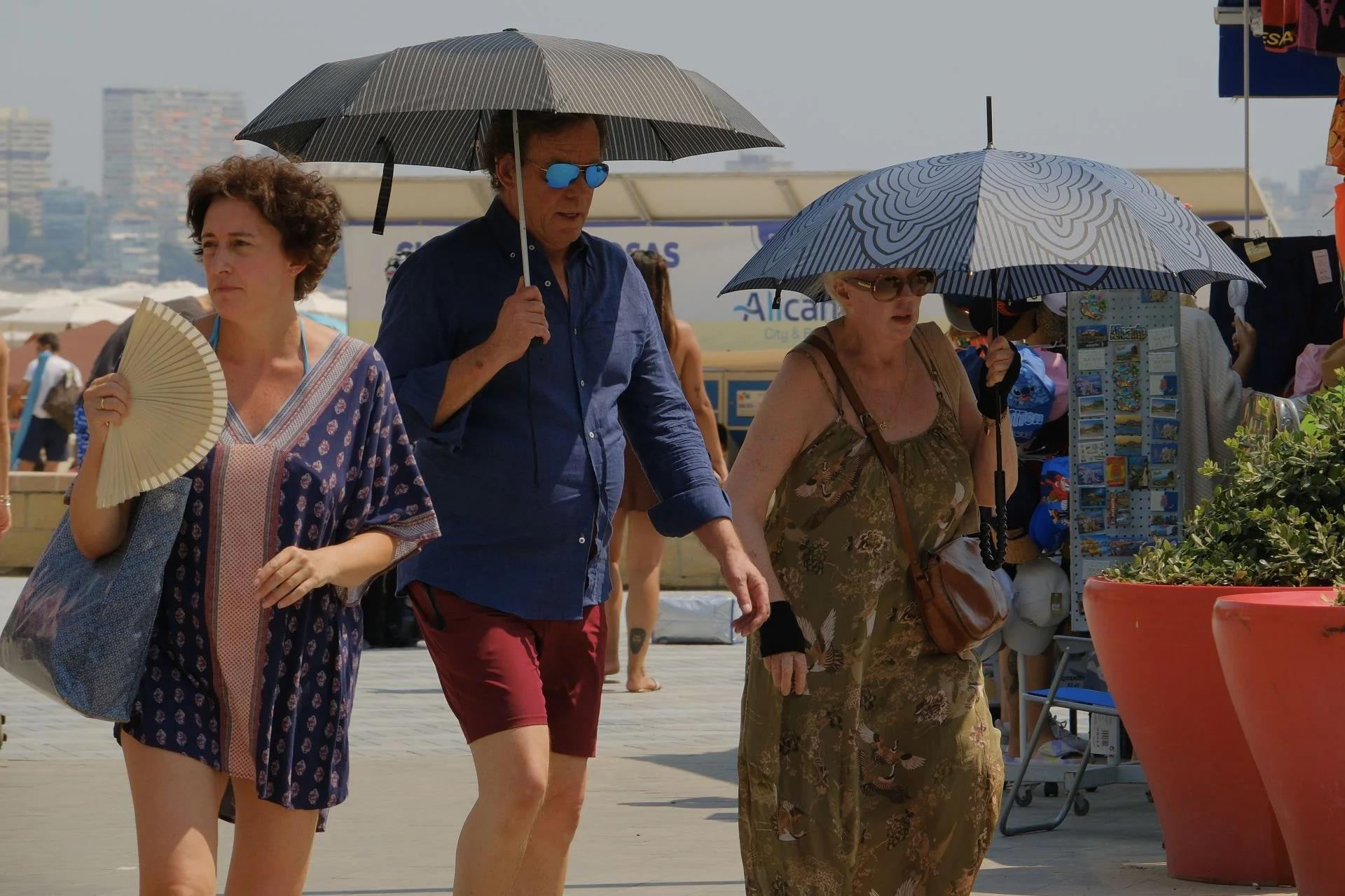 Varias personas combaten el calor en la playa del Postiguet de Alicante.