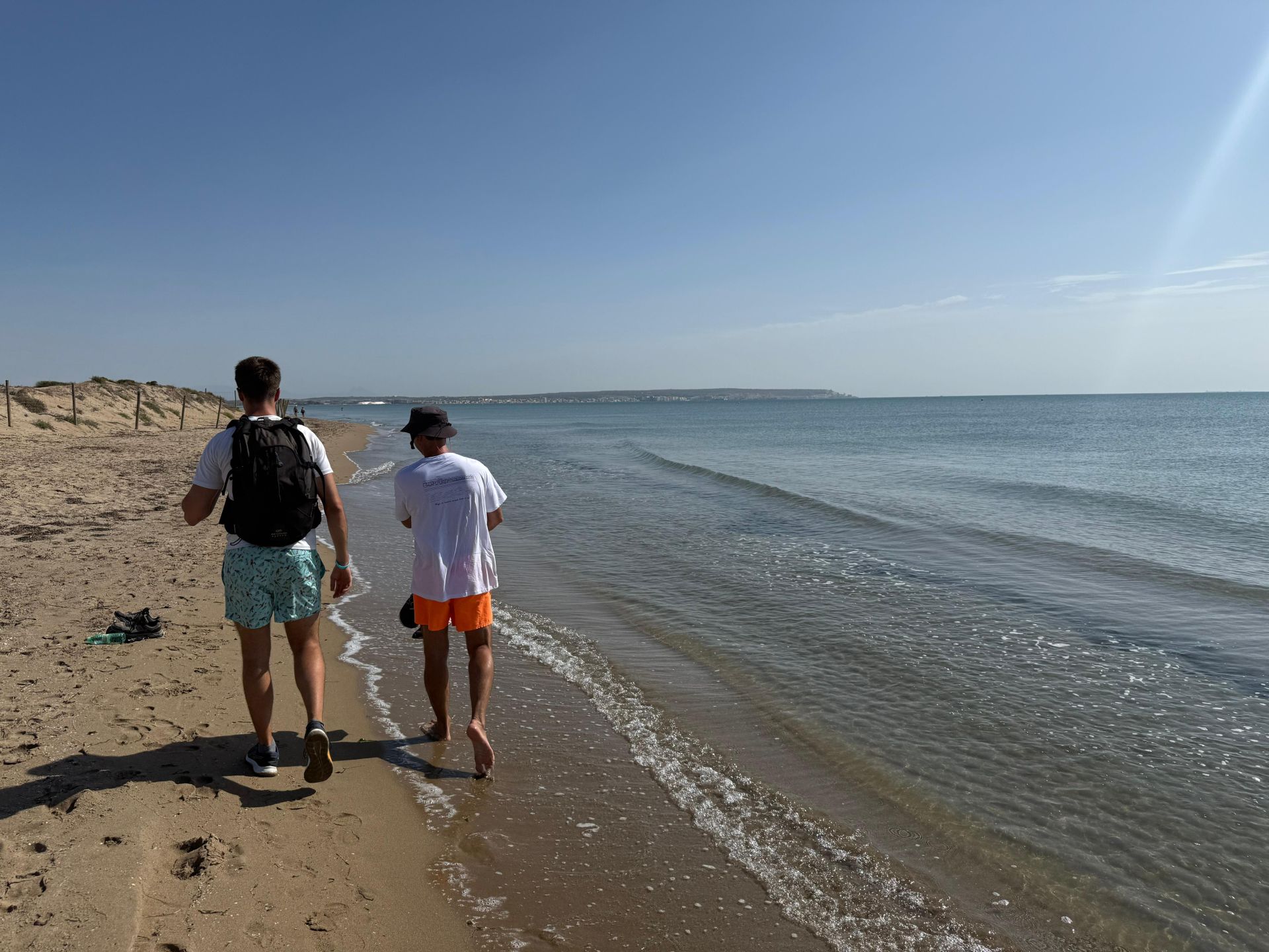 Varios vecinos caminando por la playa hacia Alicante.