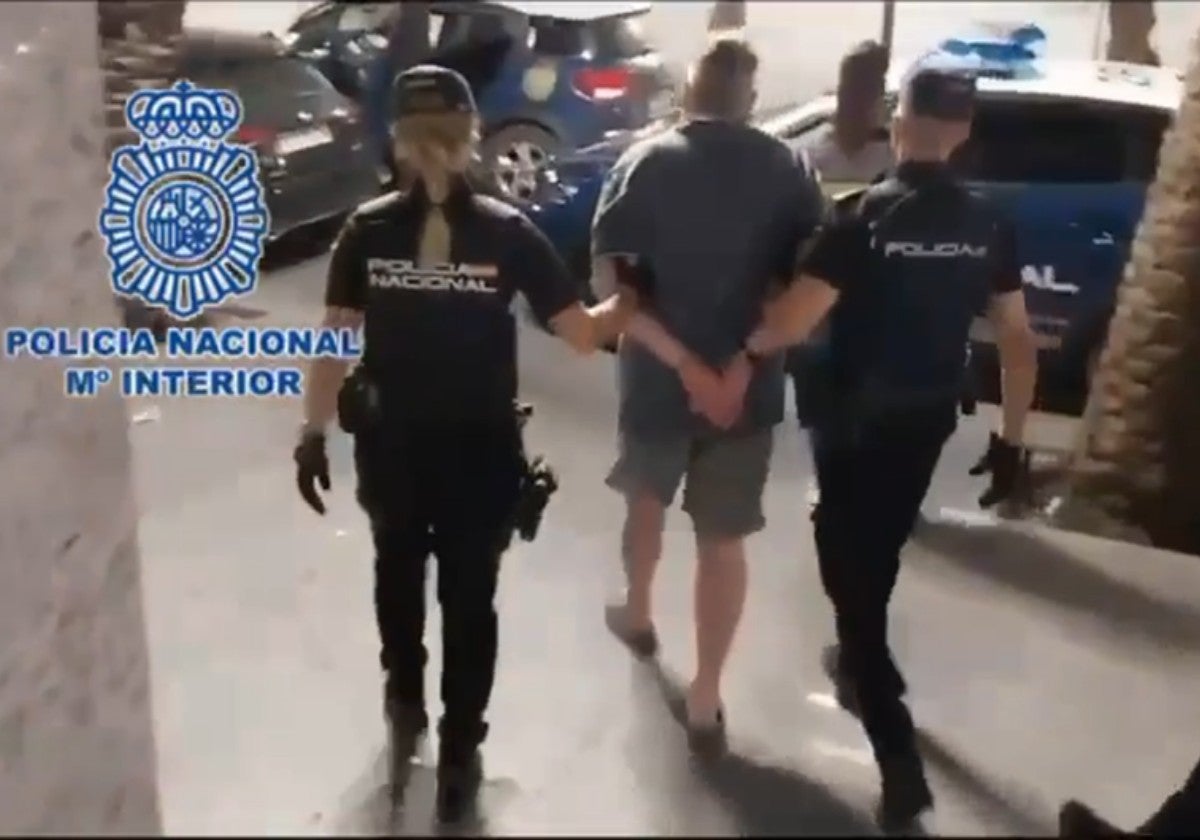 Policías nacionales custodian al detenido.