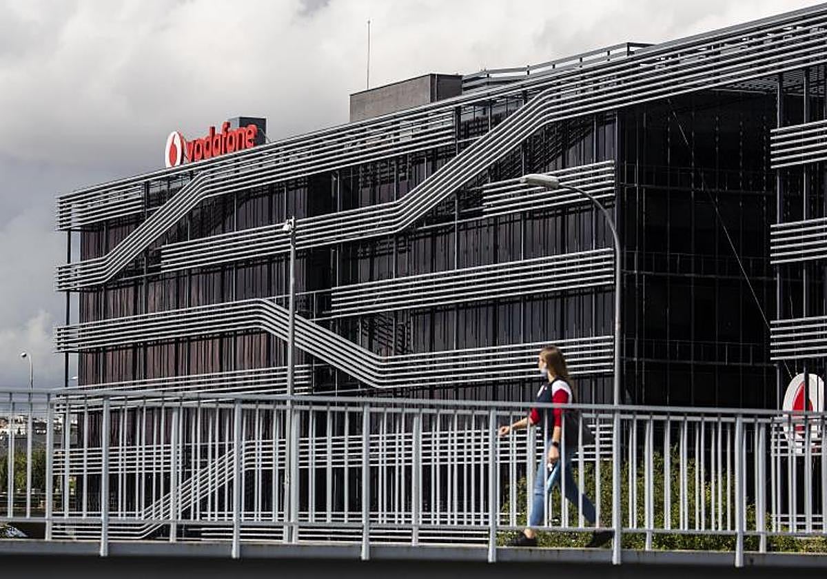 A person walks past Vodafone's headquarters in Madrid.