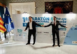 Los alcaldes de Elche y Alicante, Pablo Ruz y Luis Barcala, posan junto al cartel de la prueba.