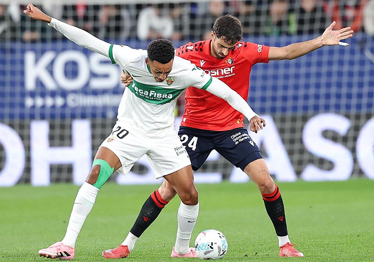Álvaro Rodríguez pelea un balón dividido con Catena en la primera mitad en El Sadar.
