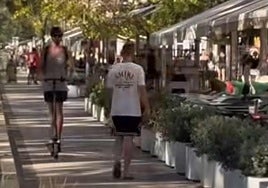 Un patinete y un peatón comparten el carril bici de la Explanada.