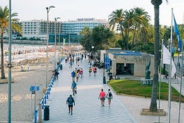 Vista de turistas paseando por la playa del Postiguet, en Alicante.