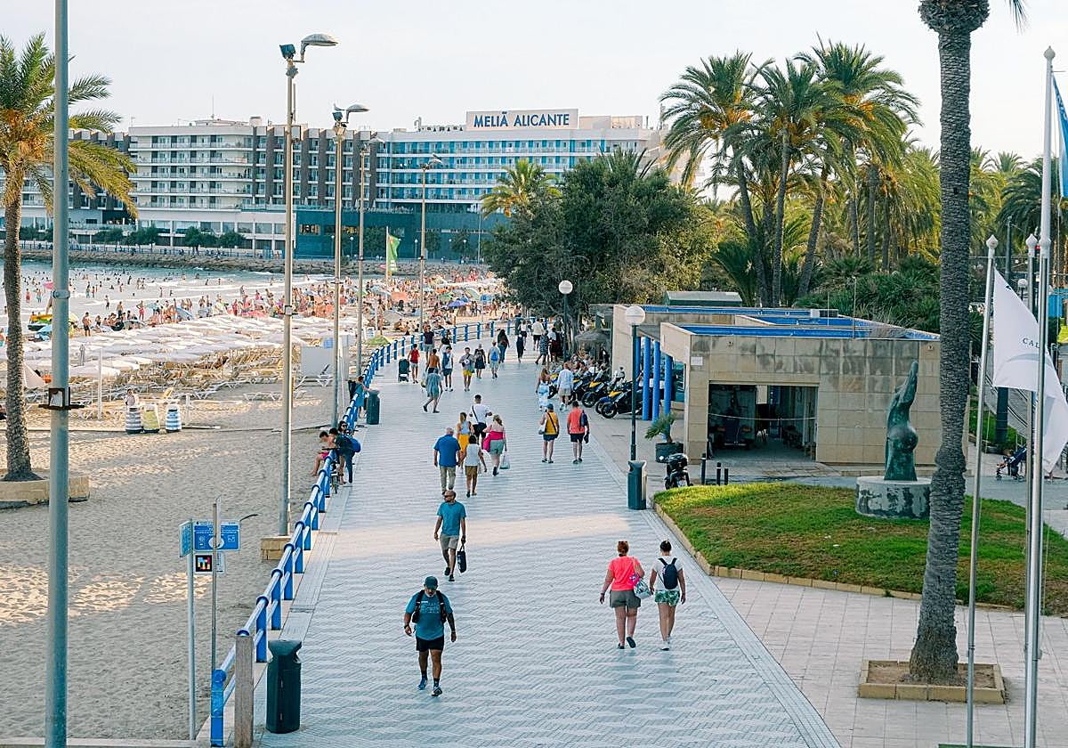 Vista de turistas paseando por la playa del Postiguet, en Alicante.