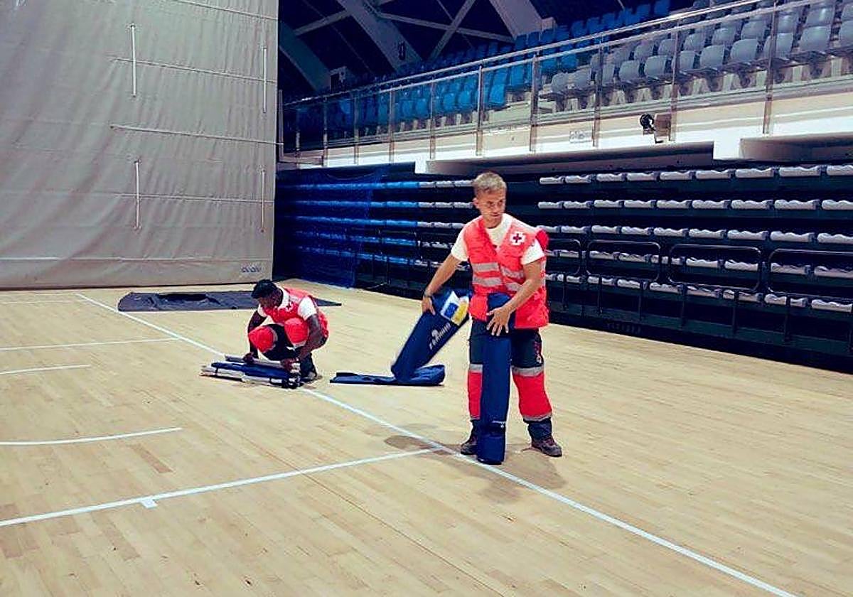 Voluntarios de Cruz Roja habilitan un albergue provisional en el pabellón de Torrevieja.