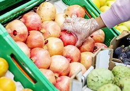 Cliente comprando granada en una tienda Mercadona.