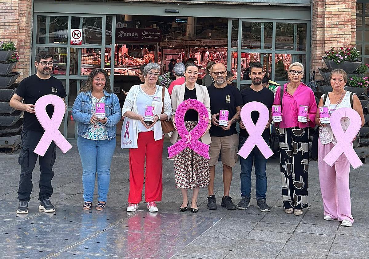 Imagen principal - Arriba, responsables de la campaña. Abajo, imagen de una hucha solidaria y cartel anunciador del acto del próximo sábado.