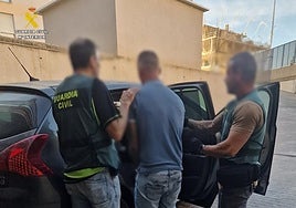 Agentes de la Guardia Civil custodian al detenido como presunto autor del disparo.