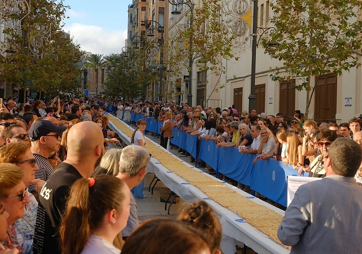 Imagen principal - Alicante elige la mejor coca de mollitas en un día para la historia: un récord de 108 metros