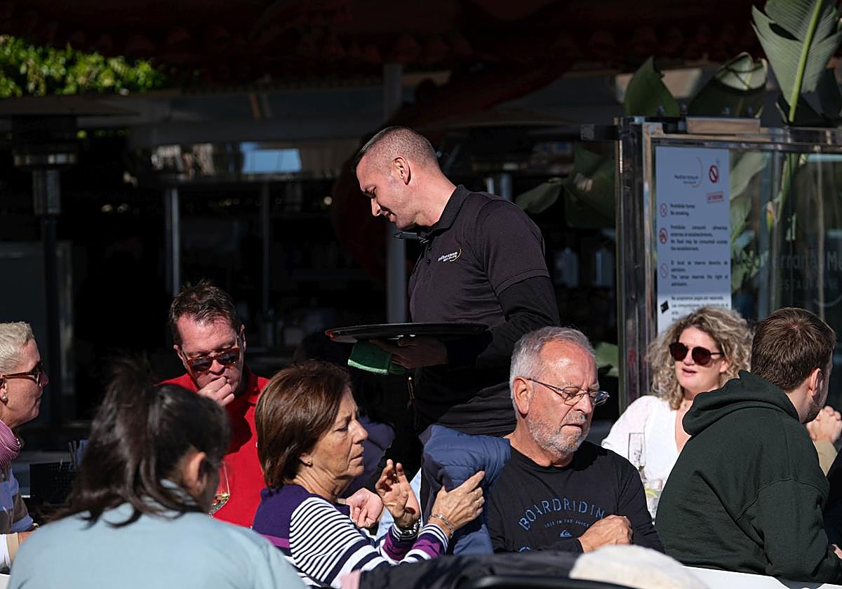 Camarero atendiendo a una mesa en un bar de Alicante.