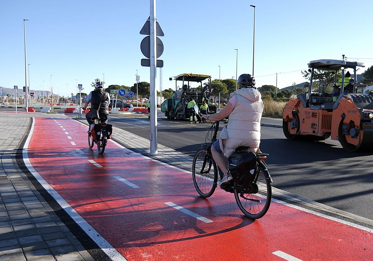 Image of two cyclists riding on the cycle path while paving works were being finalised