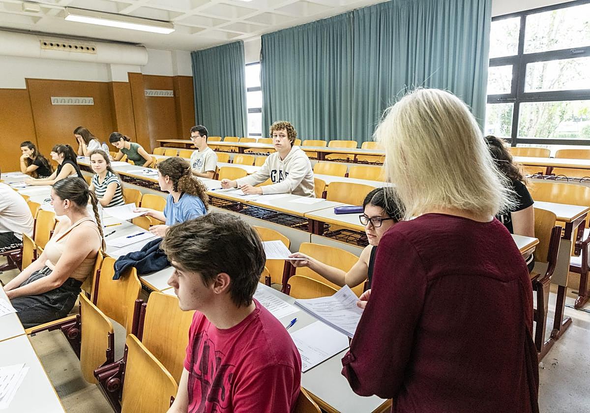 A teacher distributes exams at an educational centre in Alicante.